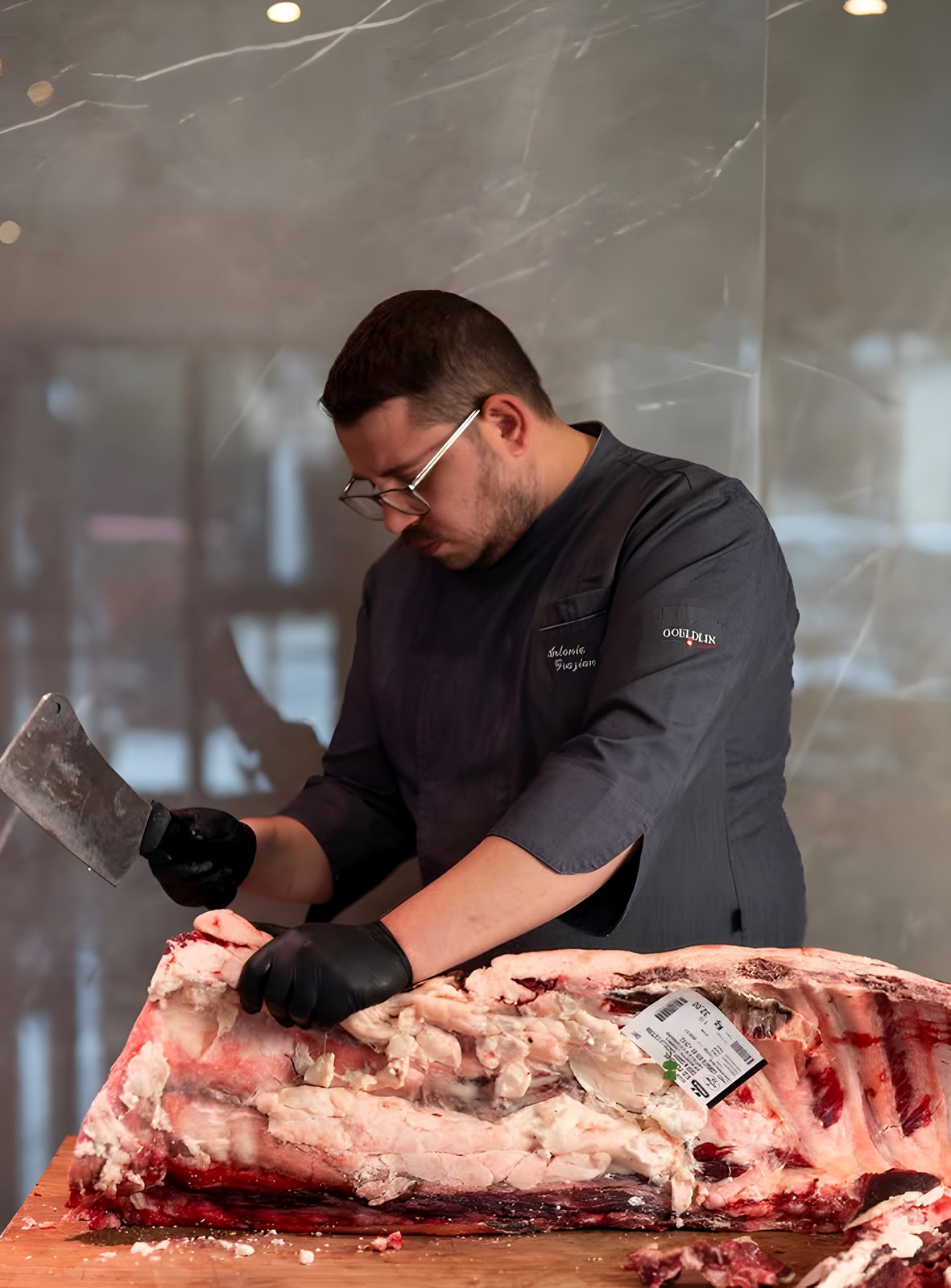 Lo chef porziona un carré di manzo frollato con la mannaia